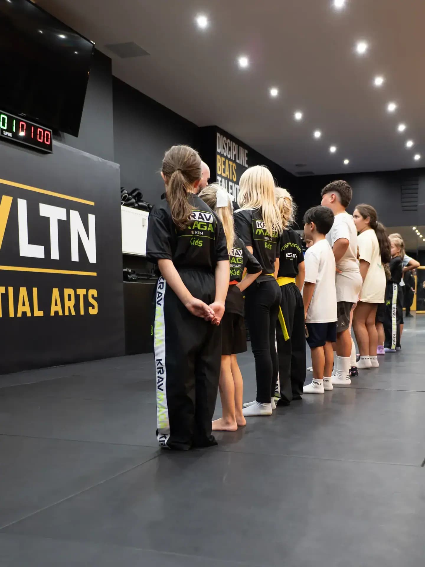 Kinderreihe mit Krav-Maga-Kids-Shirts vor Discipline Beats Talent bei EVLTN Martial Arts in Berlin-Steglitz